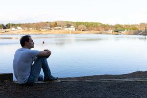 man sitting next to lake at Virginia Addiction Treatment Center Programs