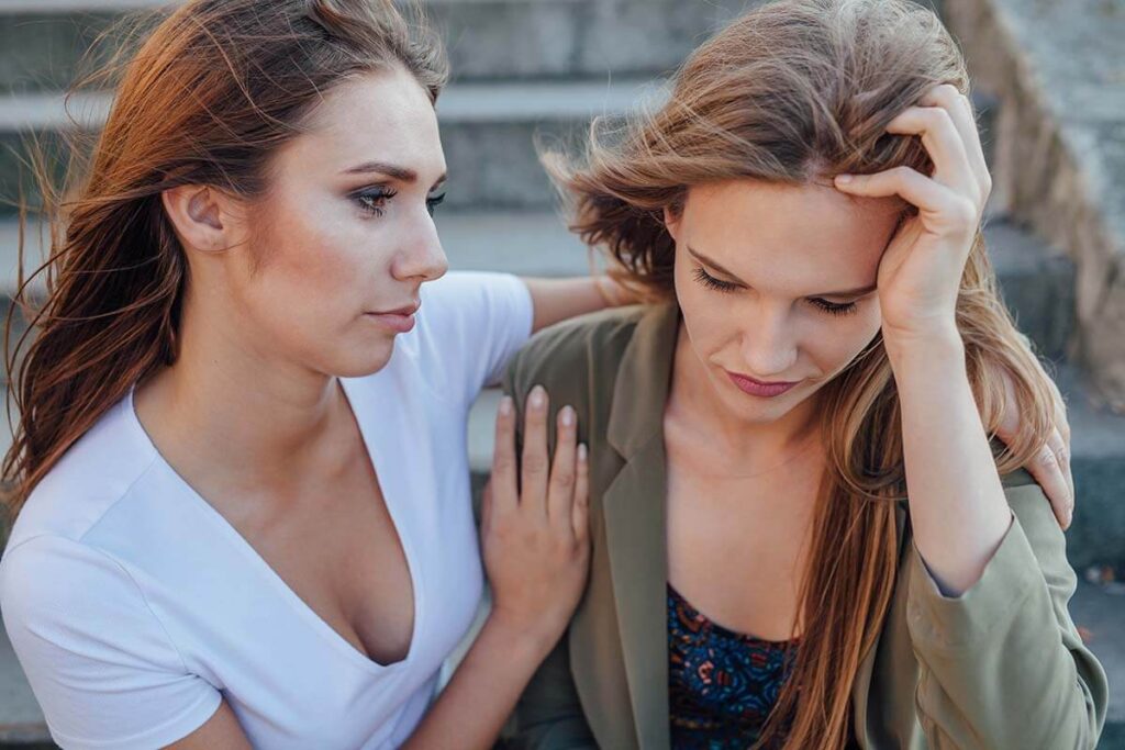 Woman consoling friend who is showing signs of anxiety