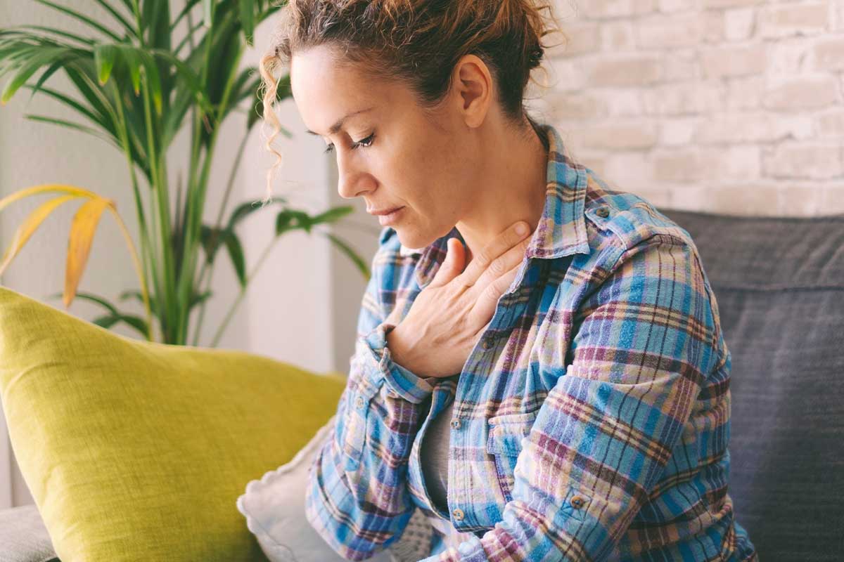 Woman with her hand on her chest struggling with how anxiety affects your body