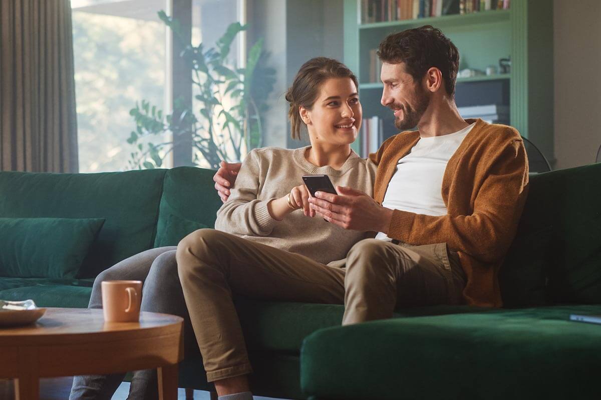 Couple sitting on couch together practicing relationship repair strategies