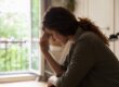 Depressed woman with her hand pressed against her forehead experiencing dual diagnosis symptoms