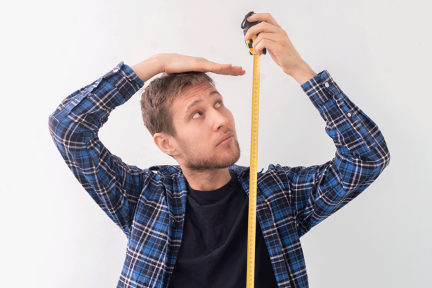 Does-Weed-Stunt-Your-Growth person measuring height with measuring tape while wondering does weed stunt your growth